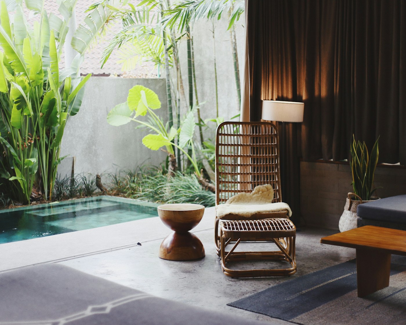 Opaline lounge — rattan chairs, greenery and a quiet pool